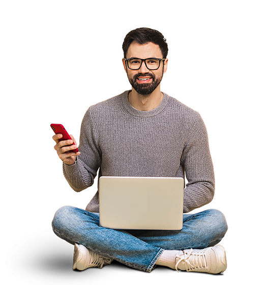 تصویری از یک مرد که چهارزانو نشسته و روی پایش لپ‌تاپ است و در دستش یک موبایل قرار دارد. این عکس در بالای صفحه اصلی وبسایت آژانس تولید محتوای نیم‌فاصله قرار دارد.
