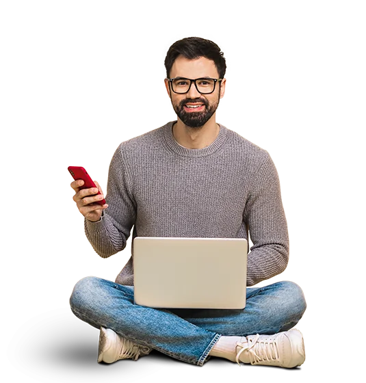 تصویری از یک مرد که چهارزانو نشسته و روی پایش لپ‌تاپ است و در دستش یک موبایل قرار دارد. این عکس در بالای صفحه اصلی وبسایت آژانس تولید محتوای نیم‌فاصله قرار دارد.